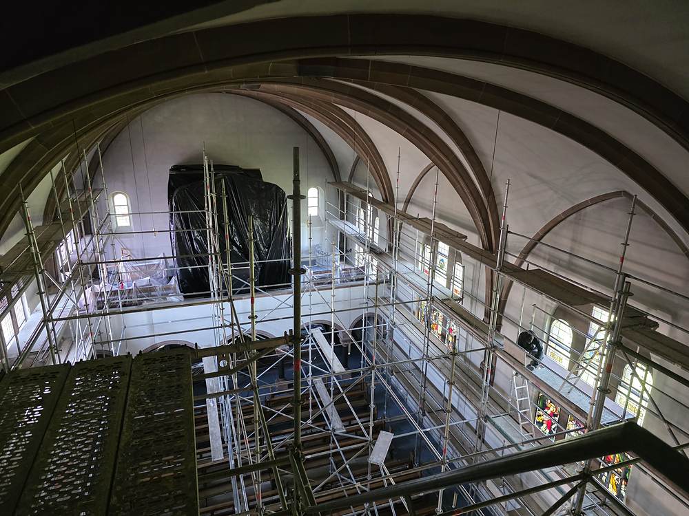 Raumgerüst im Kirchenschiff – Blick von oben durchs Gerüst bis zur abgedeckten Orgel