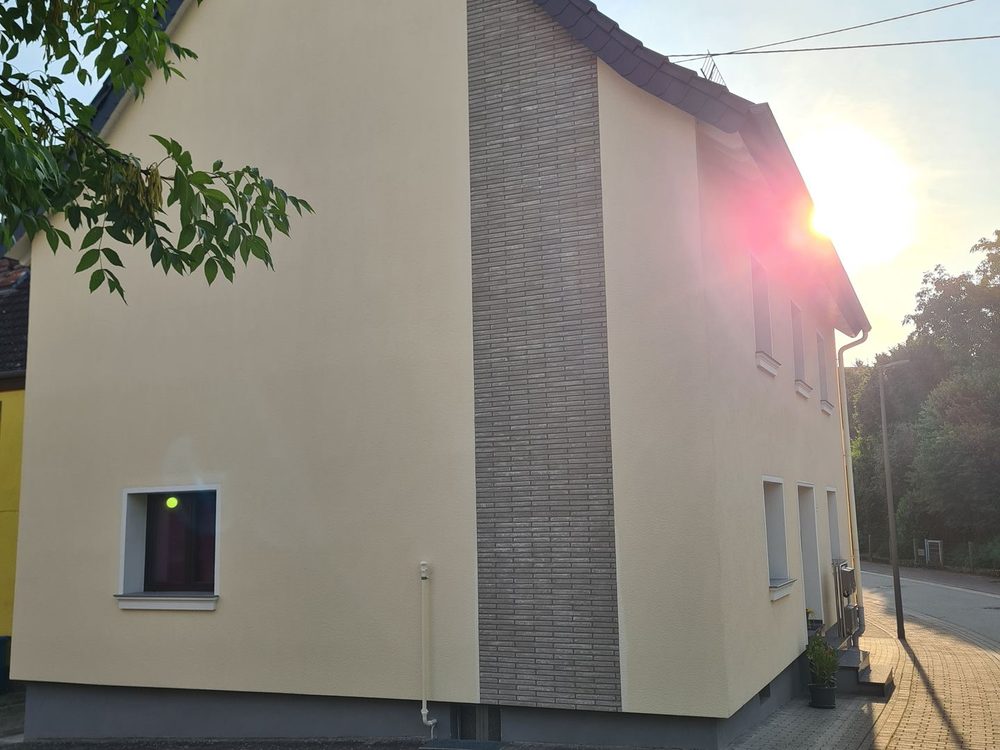 Einfamilienhaus in Pirmasens nach der Wärmedämmung – Fassade mit Steinverblender-Streifen am Giebel