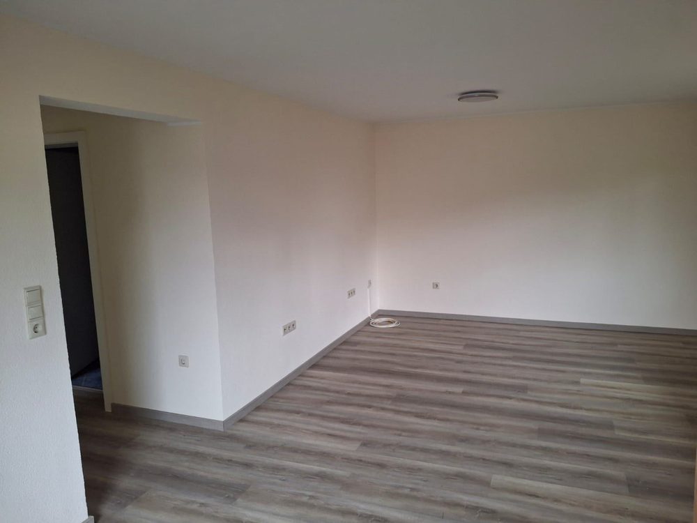 Zimmer nach dem Innenanstrich – Wände und Decke gestrichen, Boden verlegt